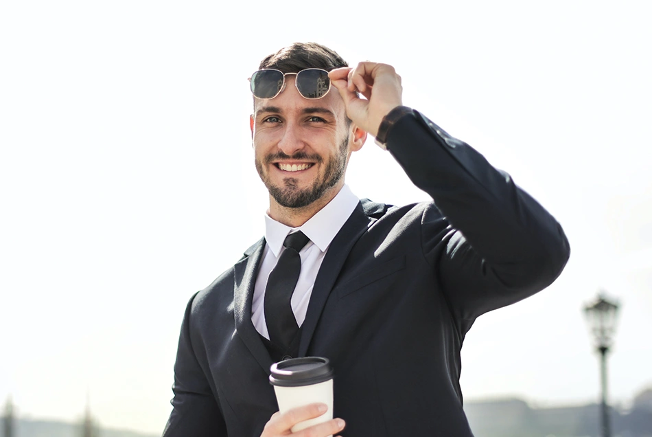 Man in a suit with sunglasses and a coffee