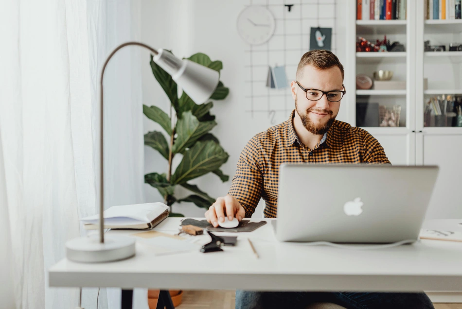 A man works on his desk at home.