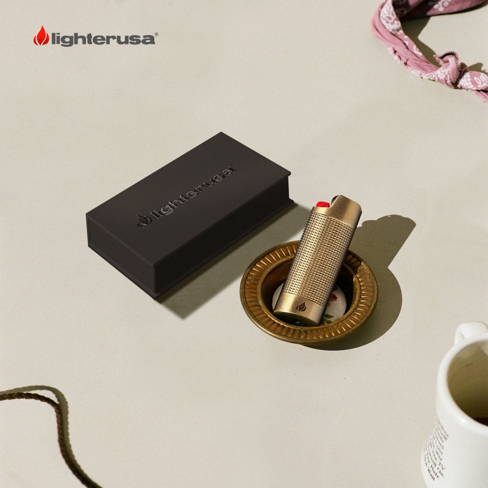 LighterUSA brand image. Gold lighter in an ash tray next to its box.