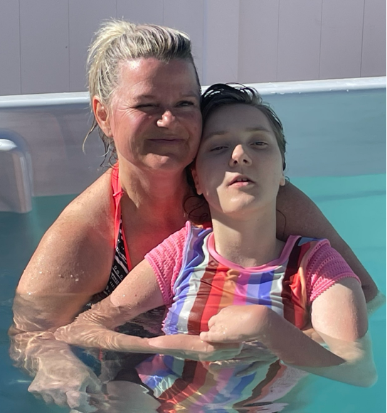 Lucy’s mom holding Lucy in a pool for hydrotherapy.