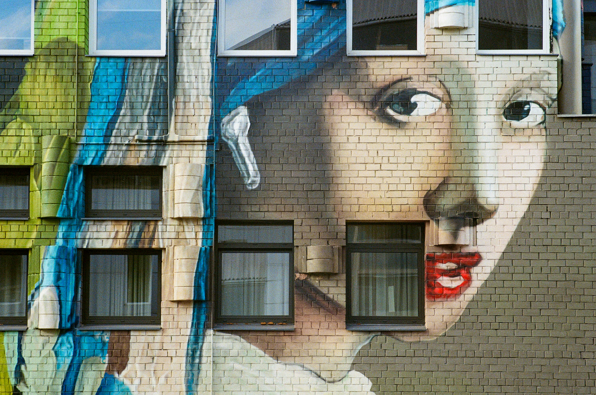 Building painted with woman portrait and her glance is upon the viewer.