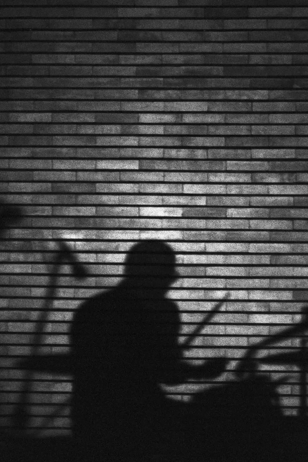 Drummer shadow on a brick wall