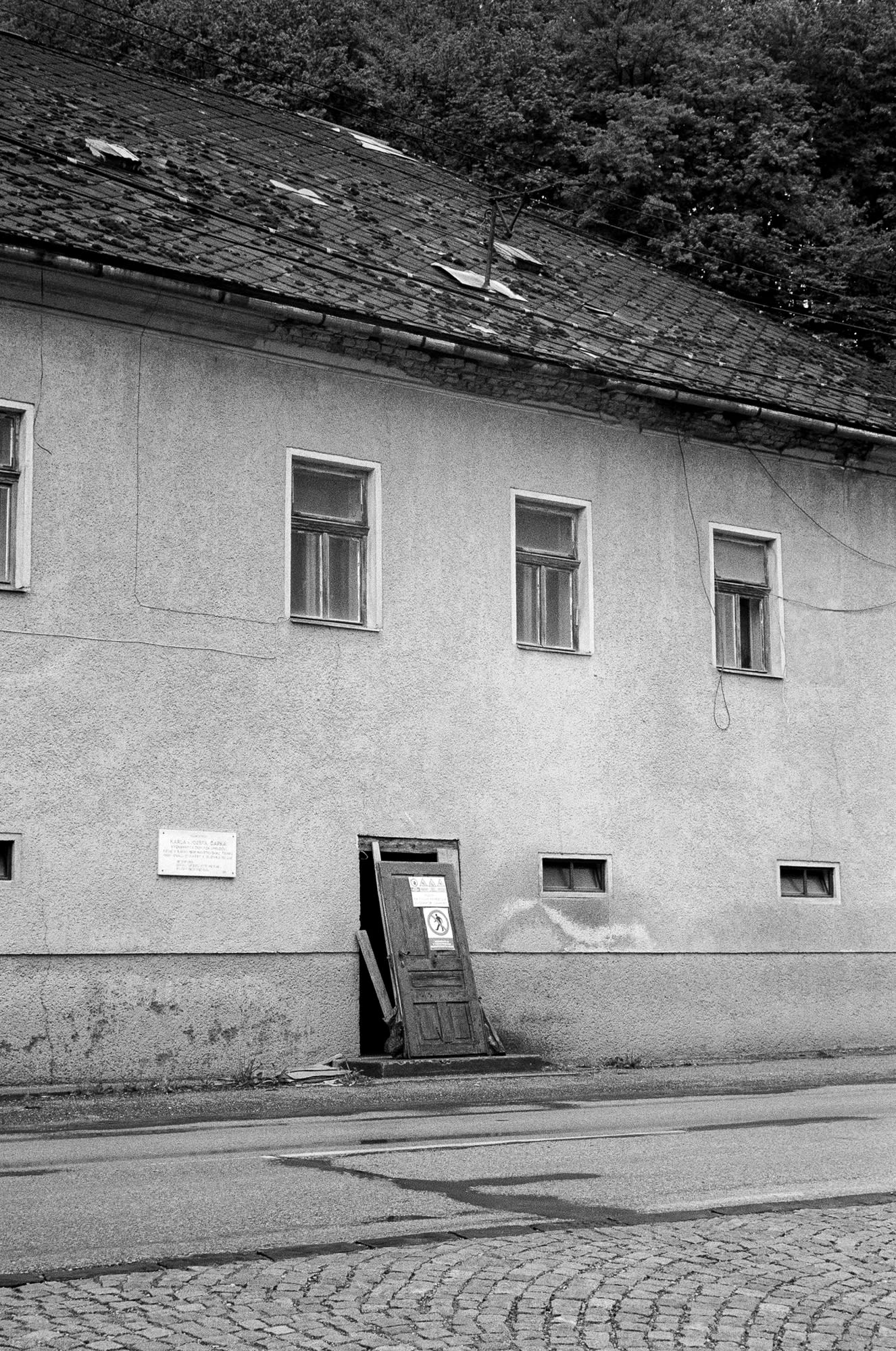 Abandoned building with doors taken out, but still leaned against the frame.