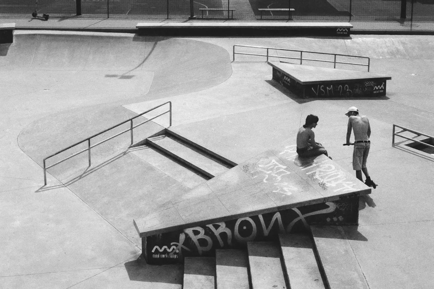 Two people talking in an empty skate park.