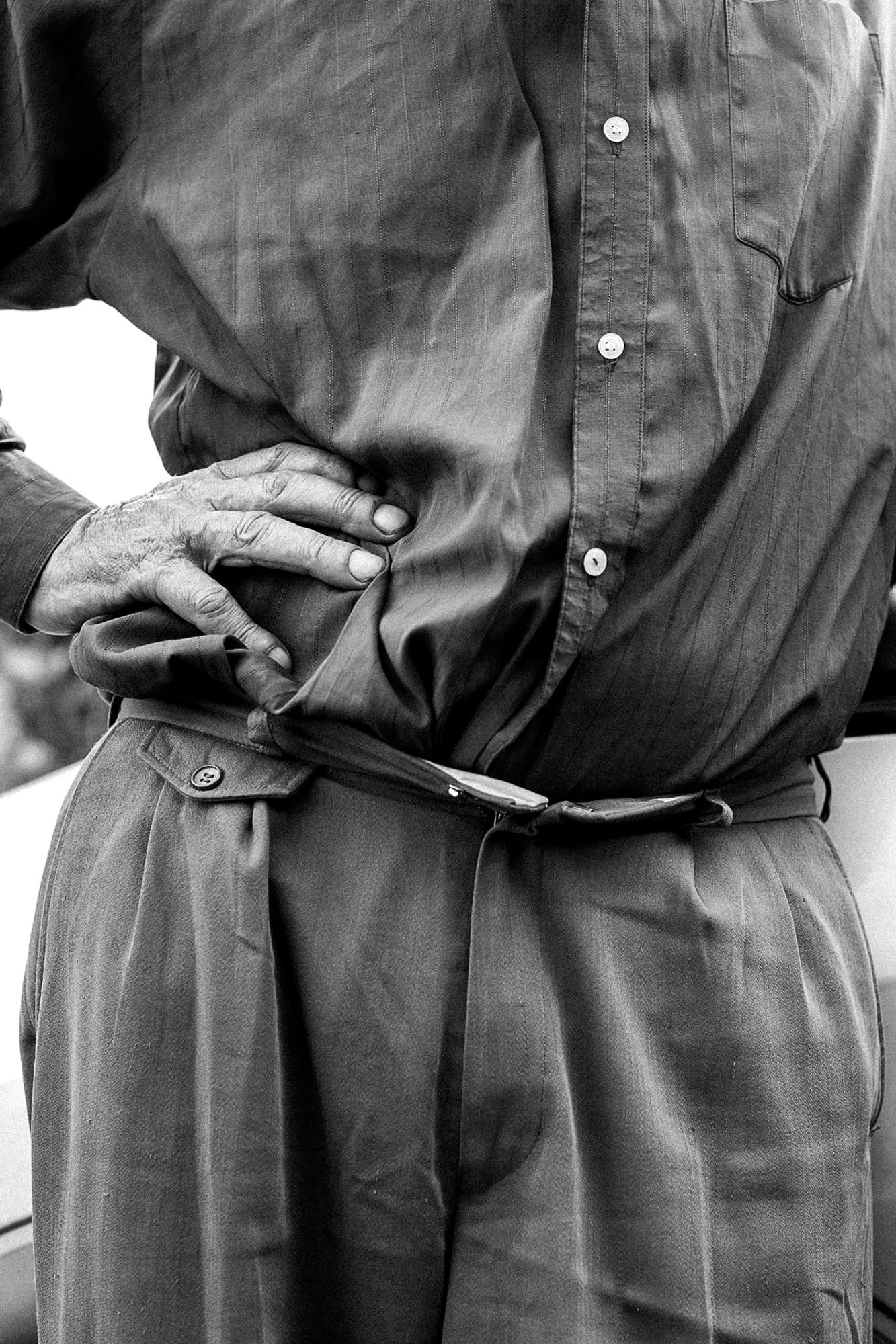 A middle body of a man and his hand on the hip.