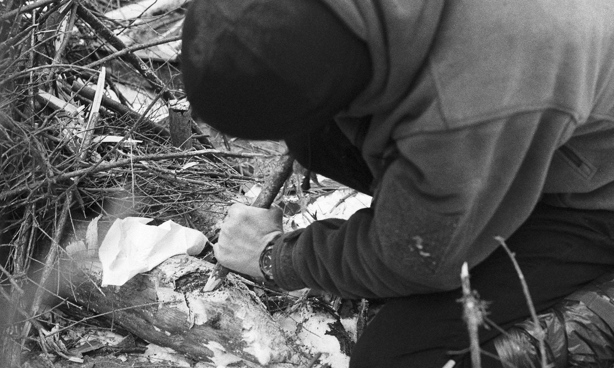 Photograph of a man trying to make fire in old ways. Black and white, taken by me.