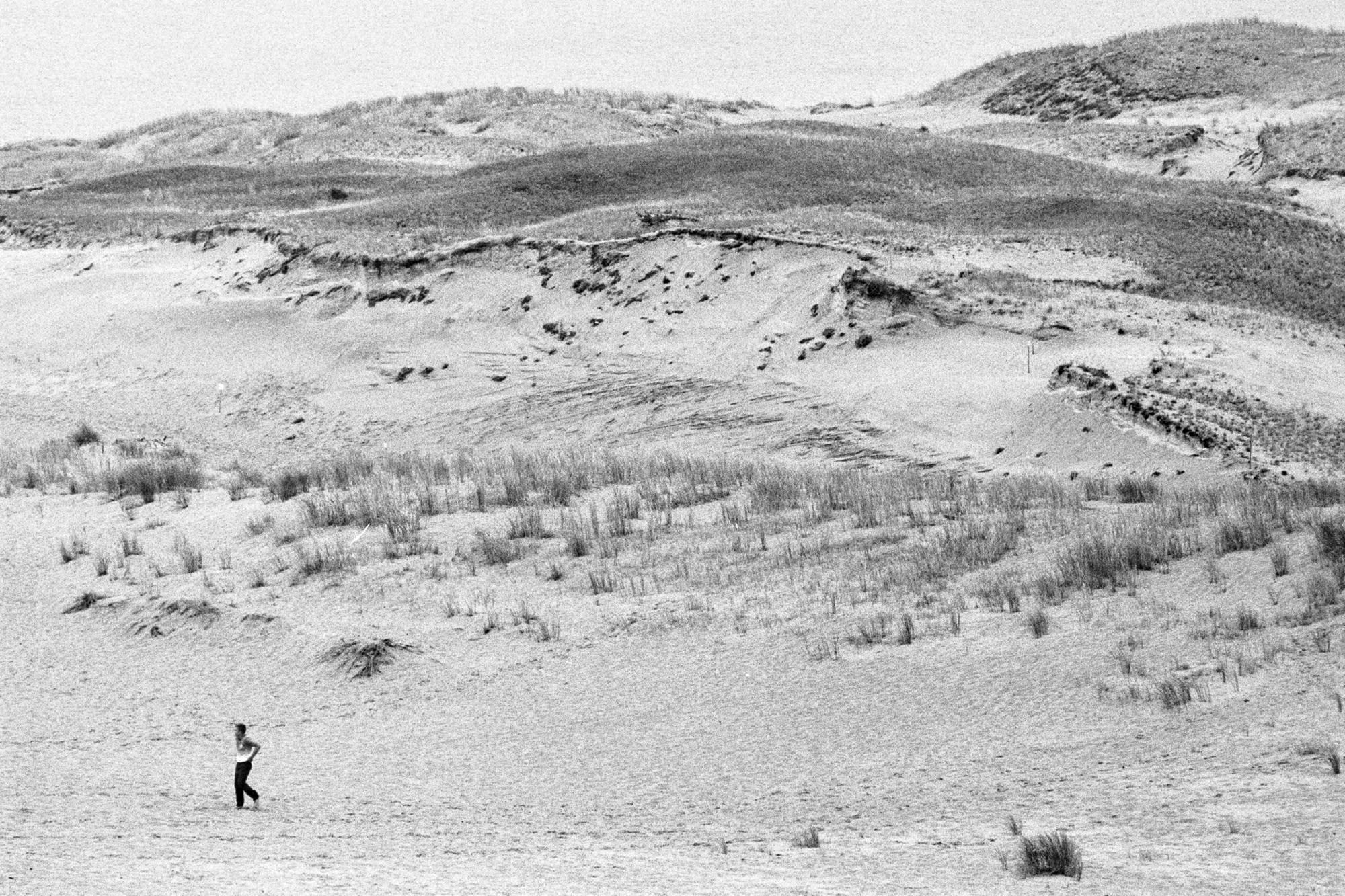 A lone person against a large body of dunes