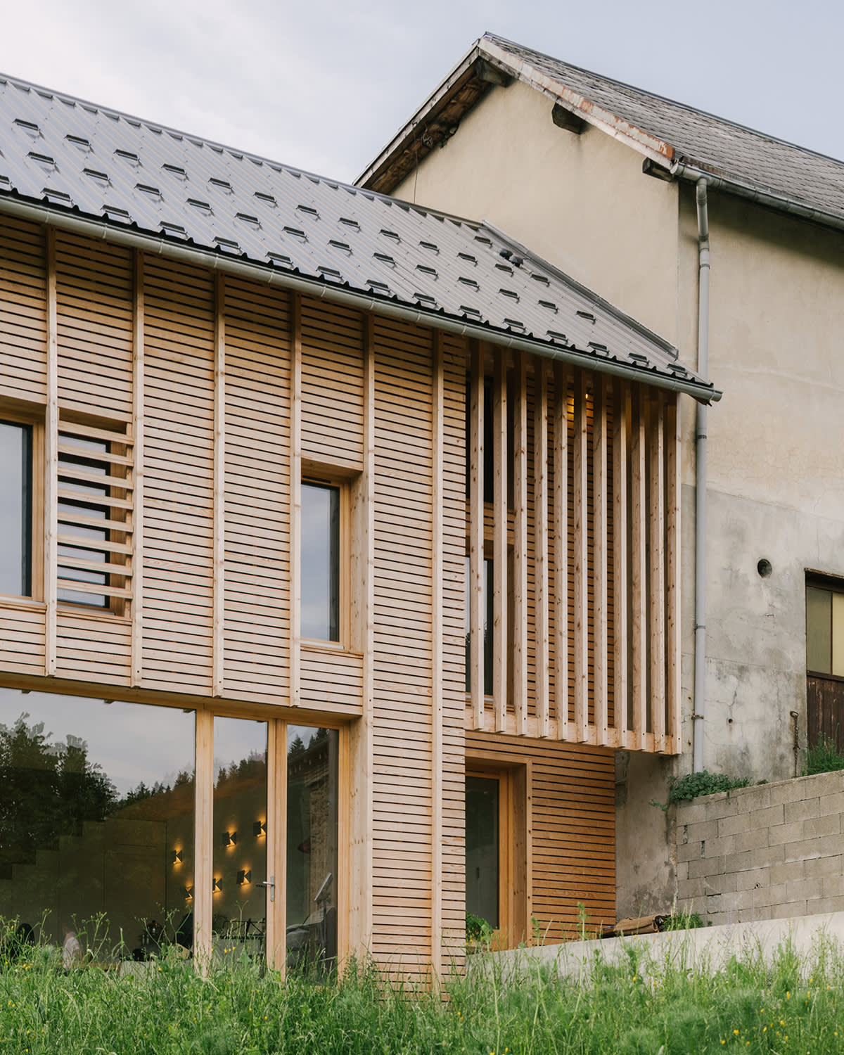 Jonction entre une extension en bois et un bâtiment traditionnel