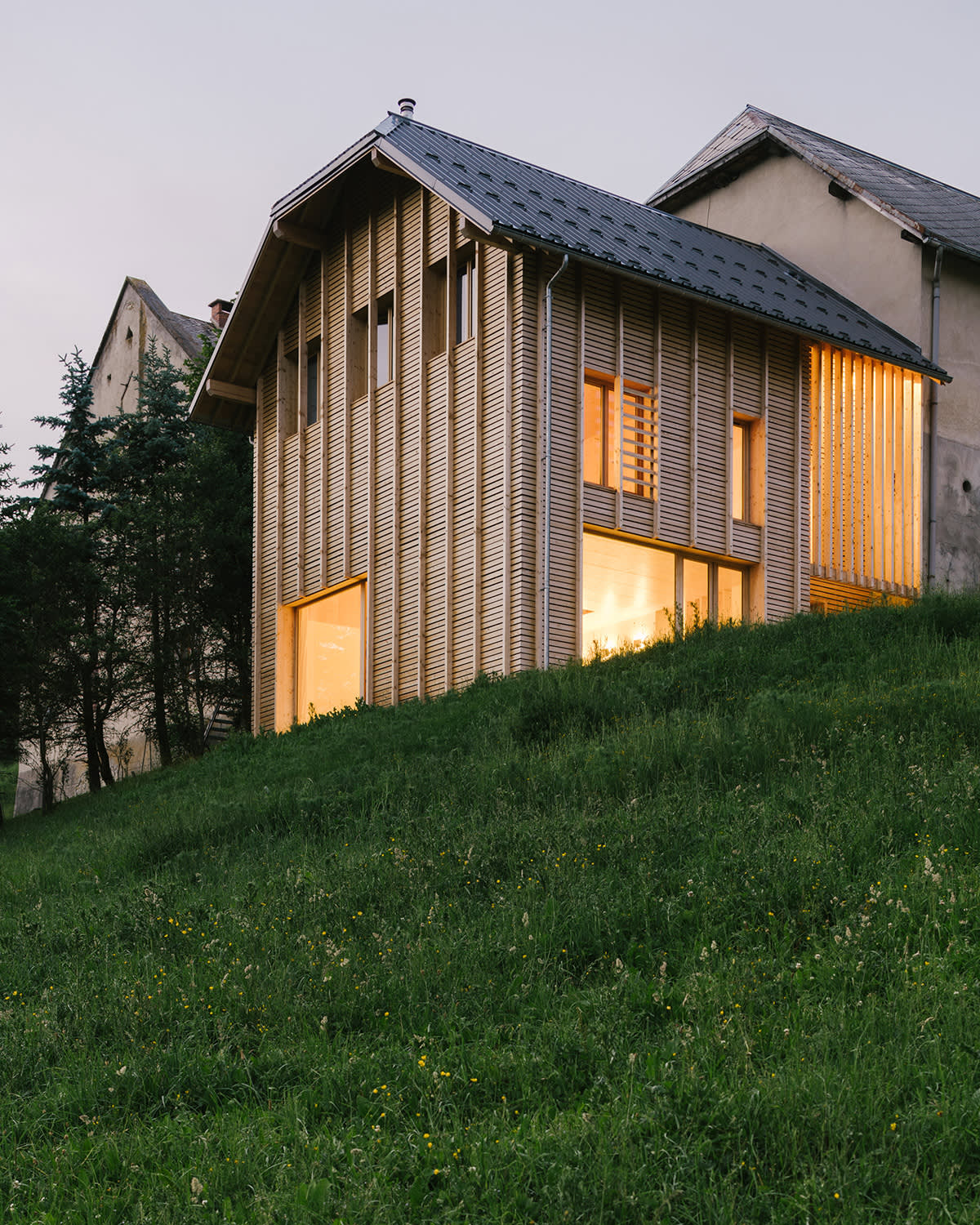 Extension en bois d'une ferme de montagne au crépuscule