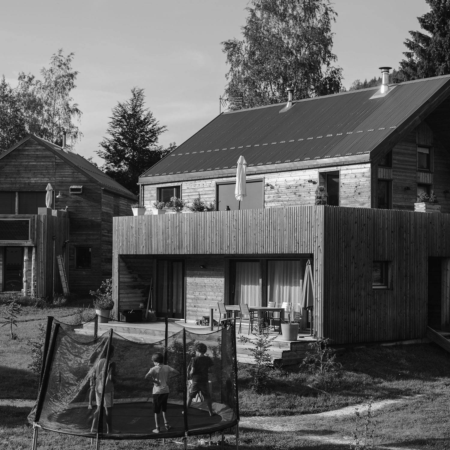 Enfants dans un trampoline et maison en bois