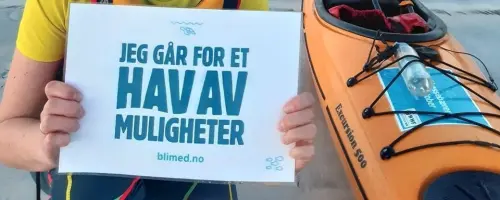 Victoria med «Jeg går for et hav av muligheter» skilt ved siden av en kajakk