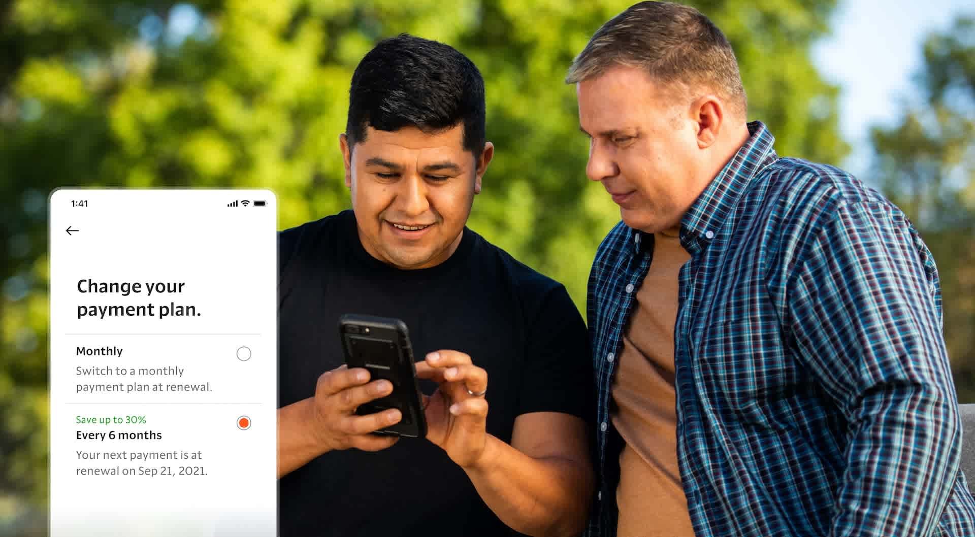 Two people looking at smartphone with an app screen showing car insurance payment options