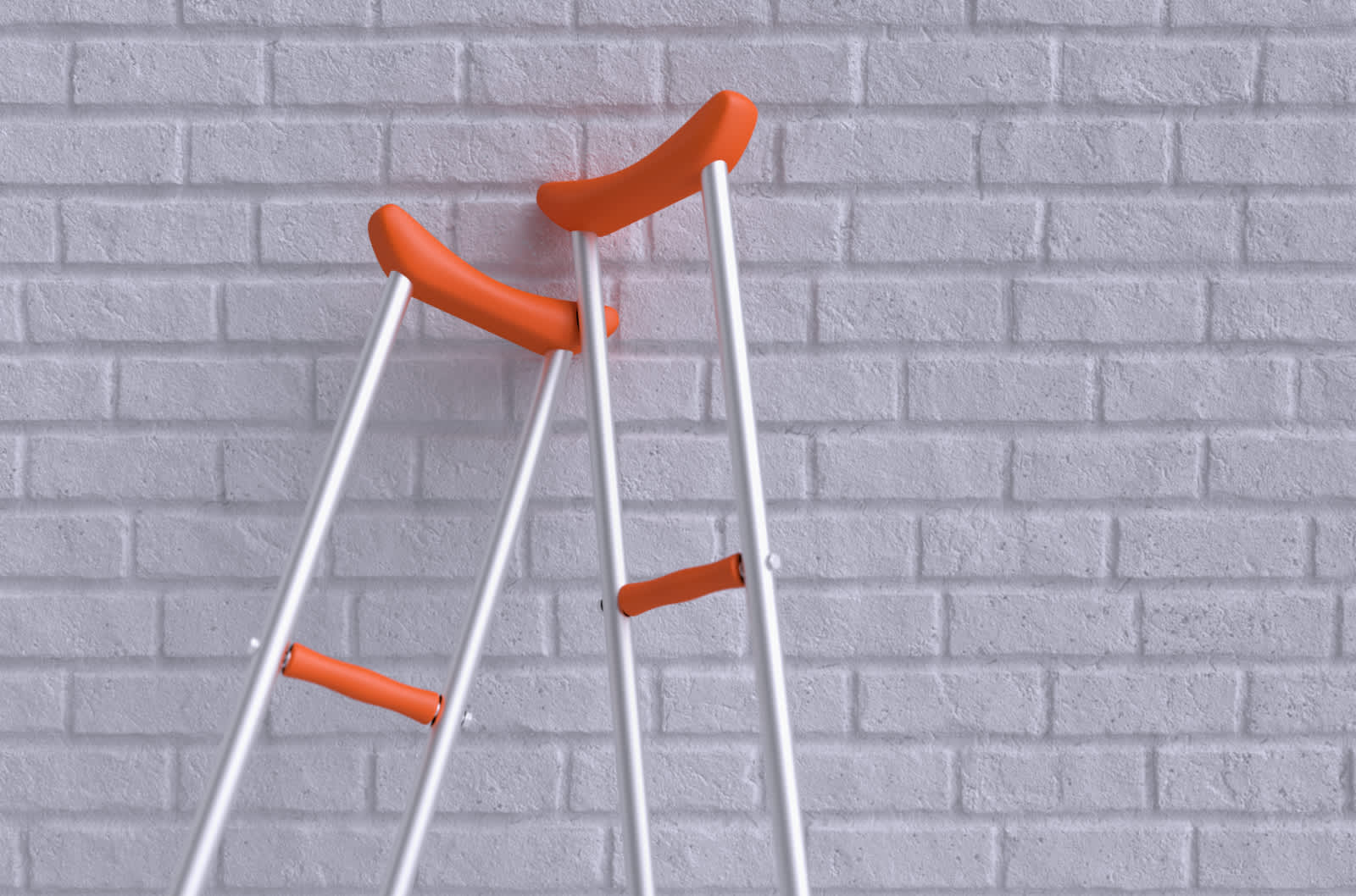Orange crutches lean on white wall