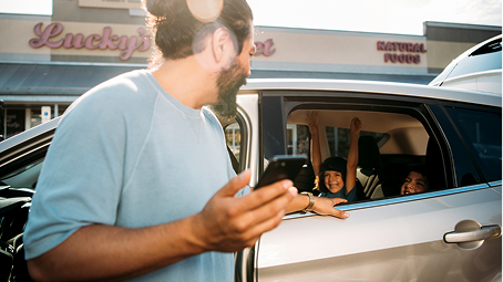 Louisiana driver exiting his car and talking to excited children in the back seat