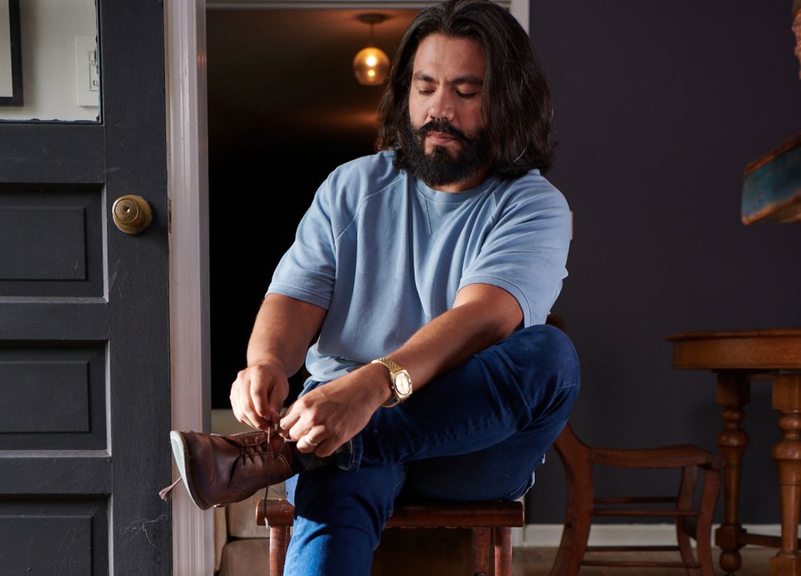 Man in home tying shoe