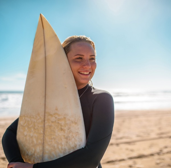 Woman holding surfboard at the beach