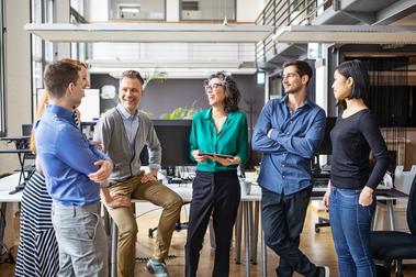 Group of 5 employees talking in the office