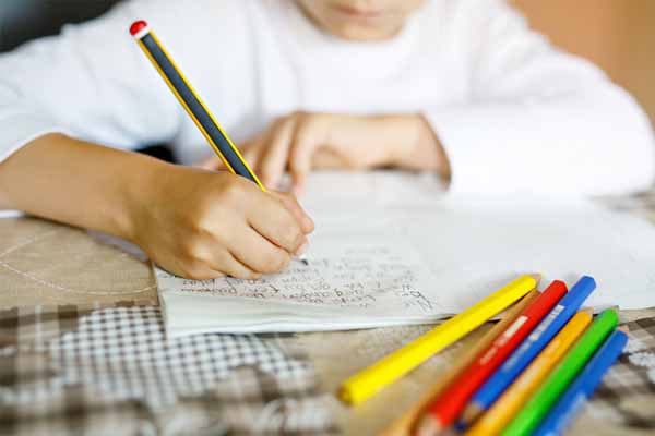 Child writing in textbook