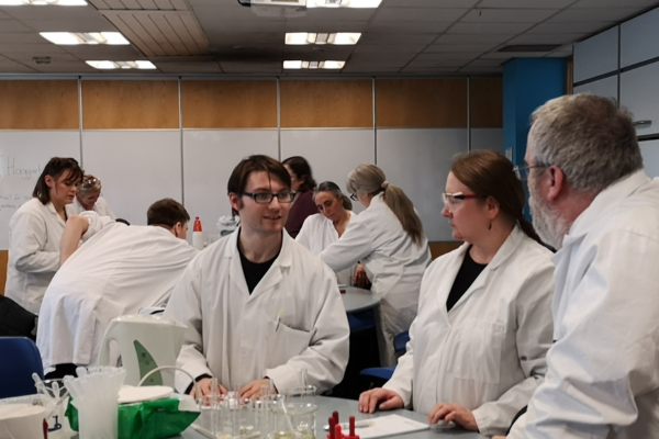 Groups of lab technicians engaged in conversation around lab benches