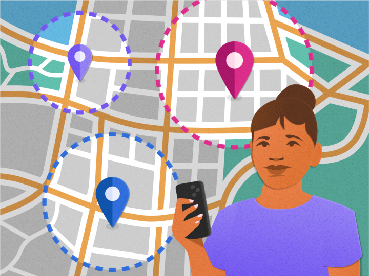 Woman stands holding cellphone with large map behind her with pinned locations