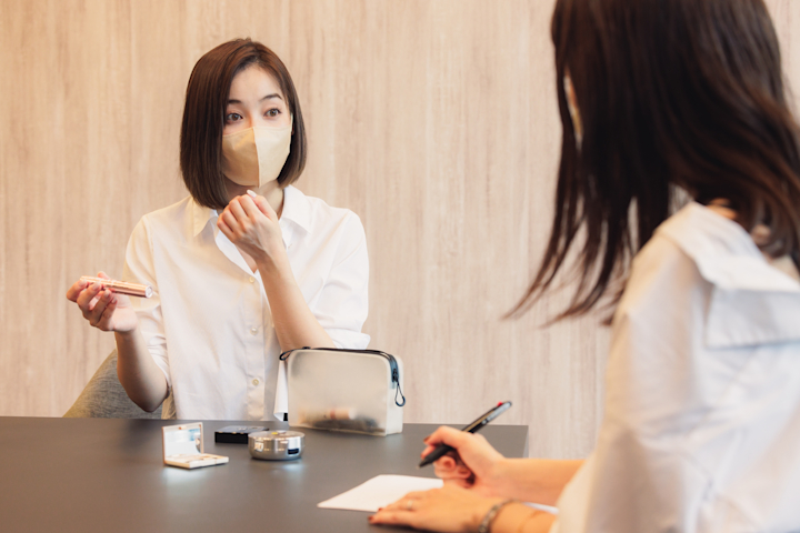 メイク道具を手に説明する山口さんの画像