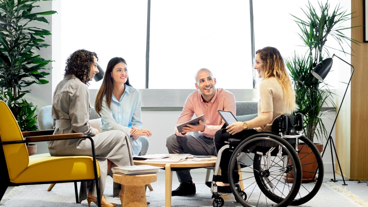Four employees talk to each other while seated in a circle.