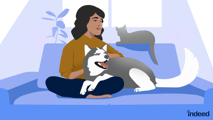 A person sits on a couch with a dog and a cat.
