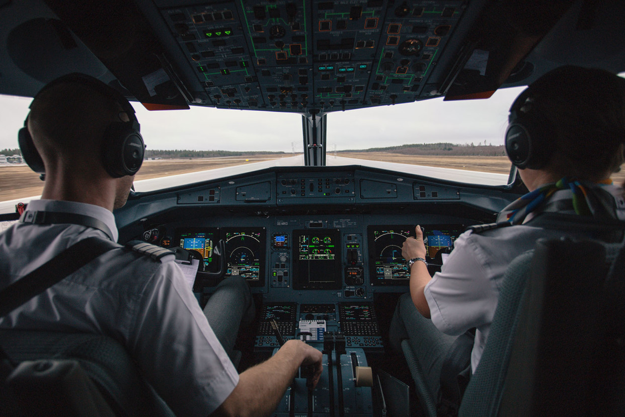 Zwei Piloten sitzen im Cockpit eines Flugzeugs.