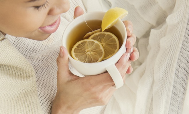 Woman drinking tea with honey and lemon