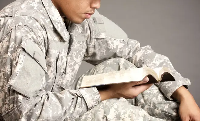 Military personnel reading a book Military personnel reading a book