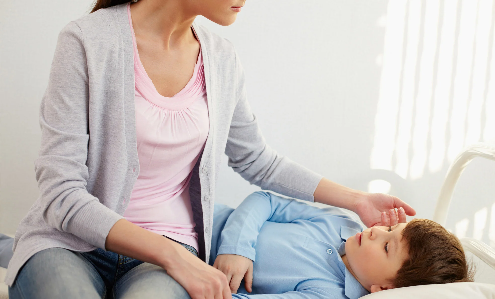 Woman checking son's cheek