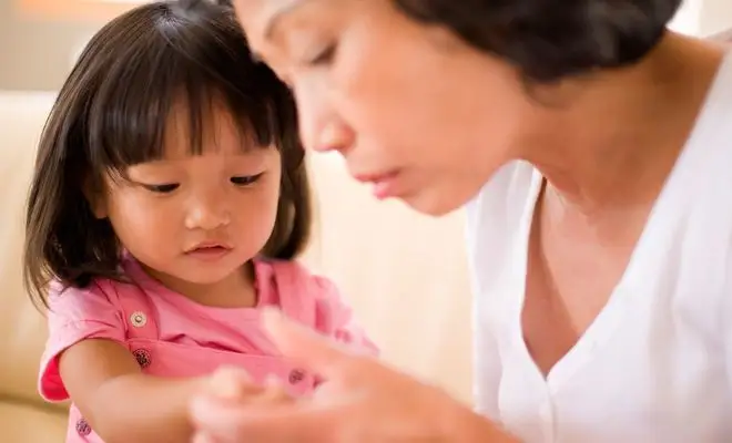 Mother checking her daughter's skin for irritants Mother checking her daughter's skin for irritants