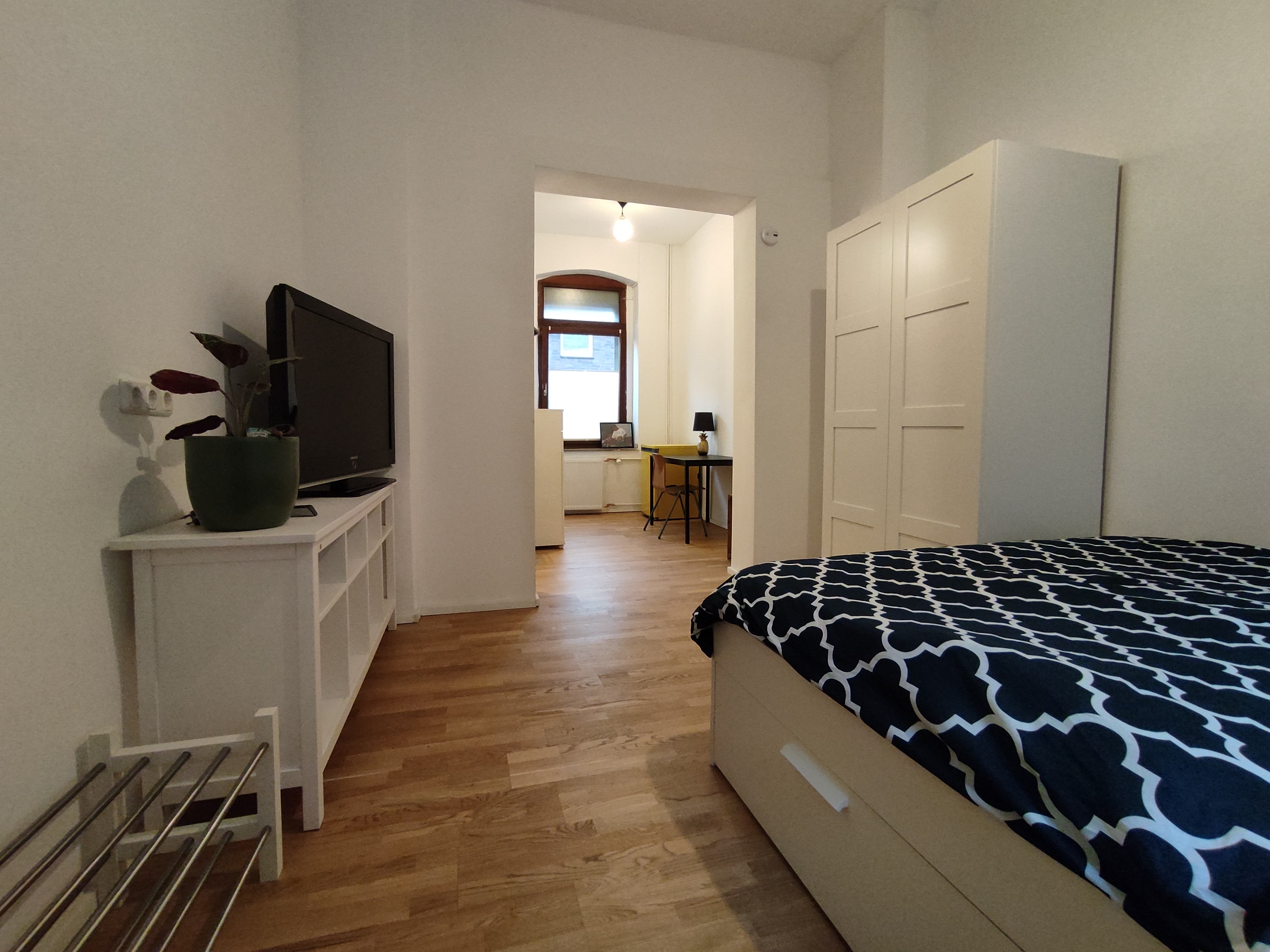 Schlafzimmer mit Blick zum Essbereich und Küchenzeile