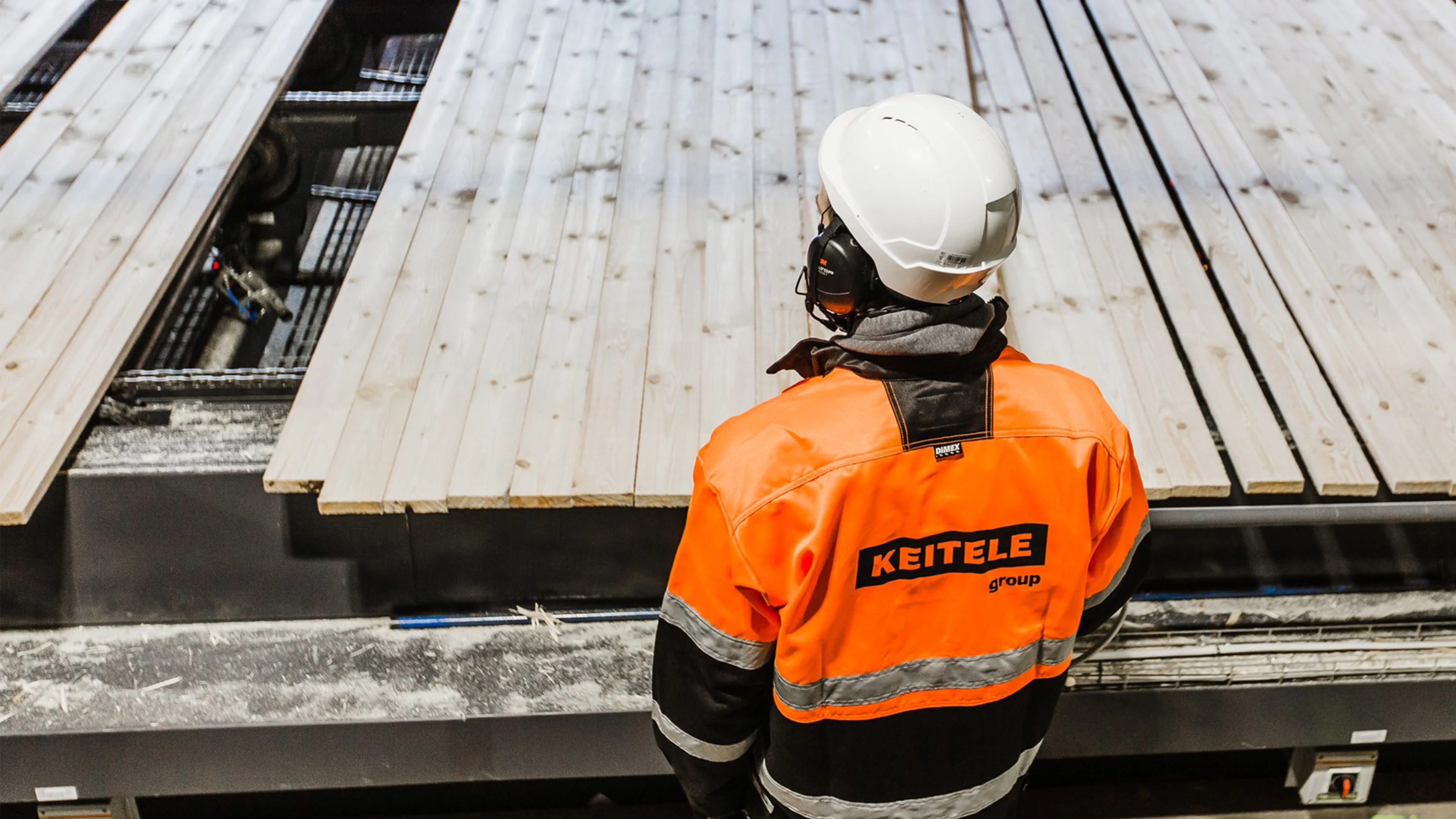 Työntekijä Keitele Groupin tehtaalla valvomassa sahatavaran tuotantoprosessia.