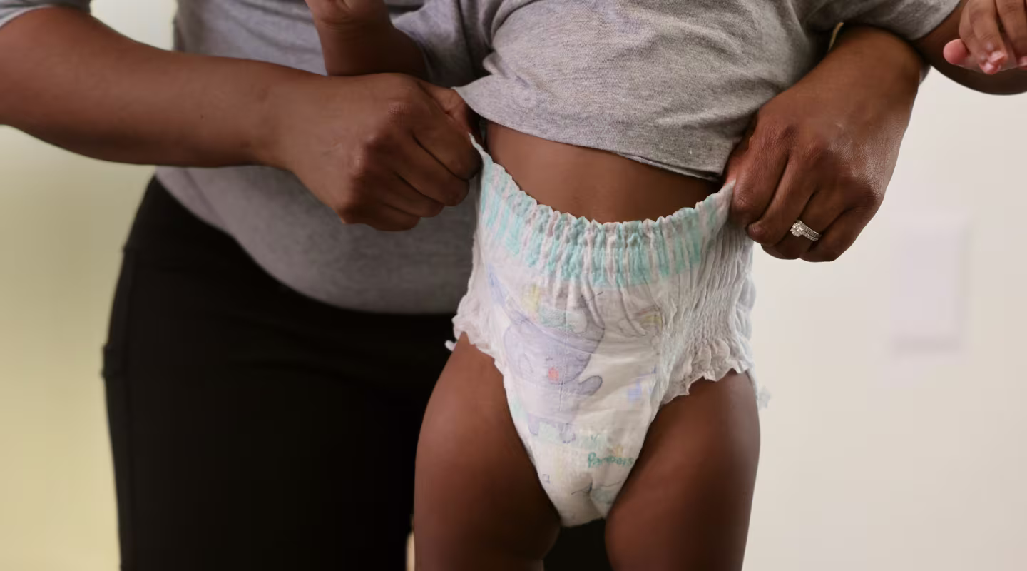 Une vue rapprochée d’un bébé portant une couche Swaddlers 360°, mettant en évidence sa ceinture extensible qui s’adapte confortablement à ses mouvements.