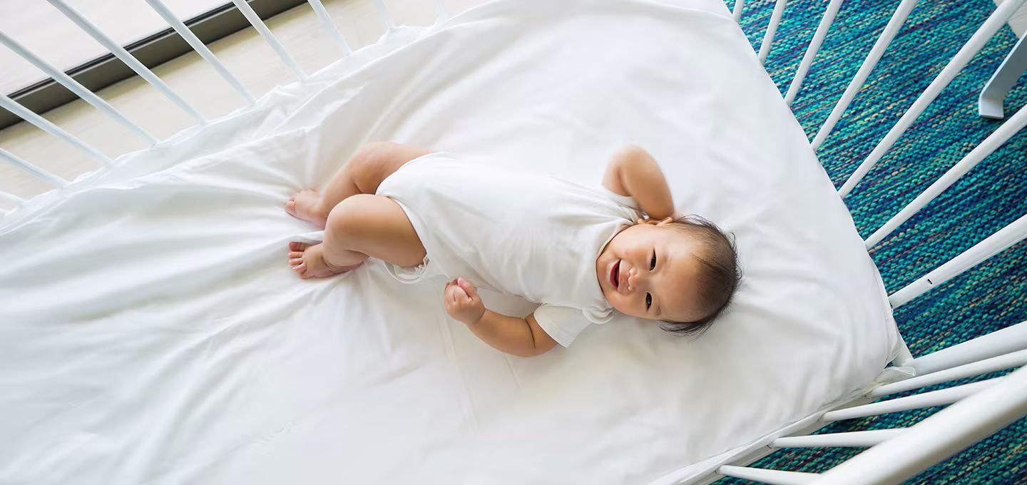 Baby fighting sleep in a crib