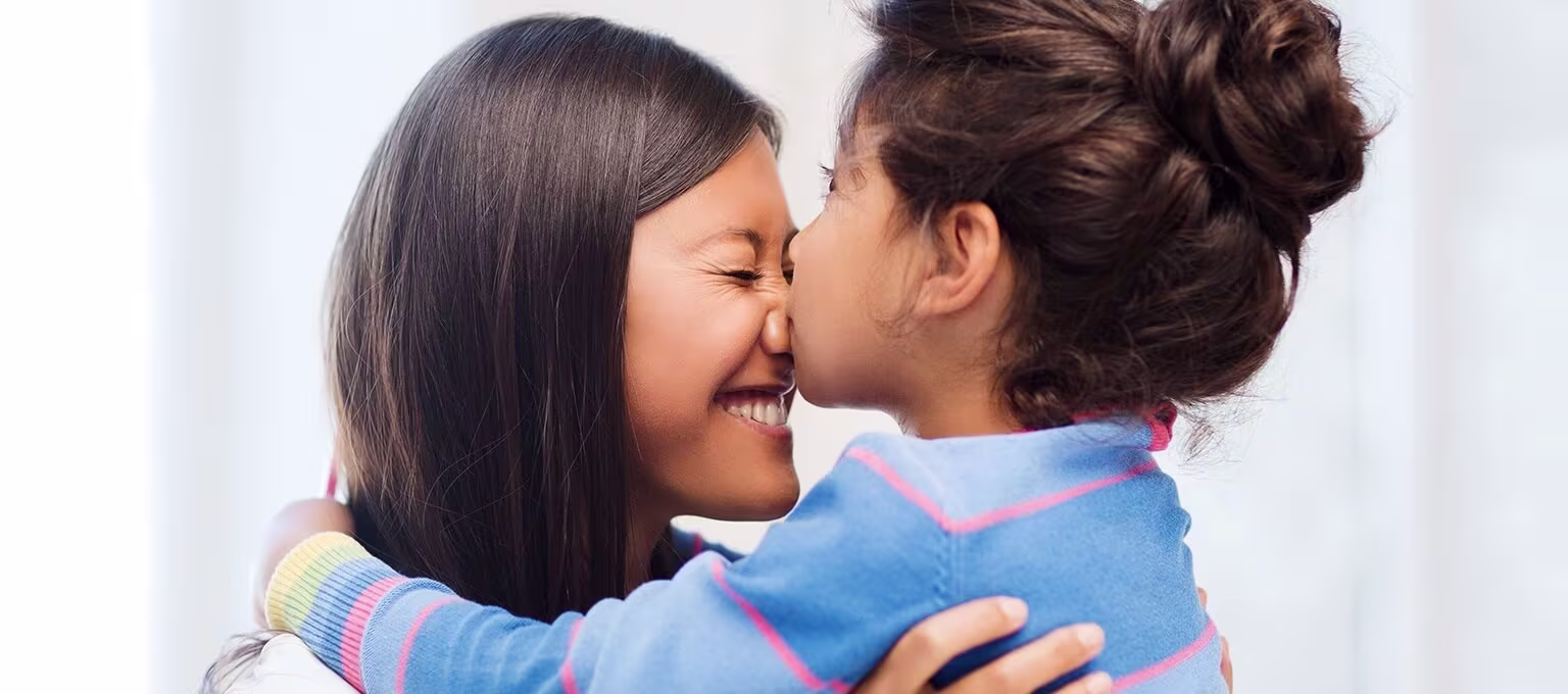 Little girl kissing mother on the nose