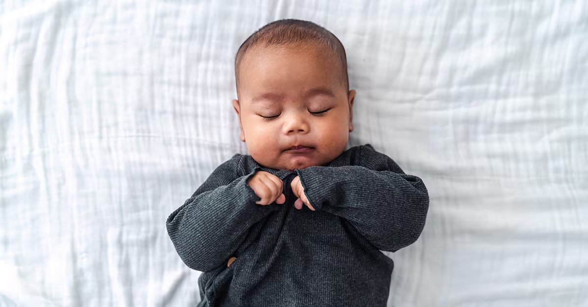 Bébé endormi paisiblement, représentant l'importance d'un bon sommeil pour gérer l'énurésie nocturne chez les enfants