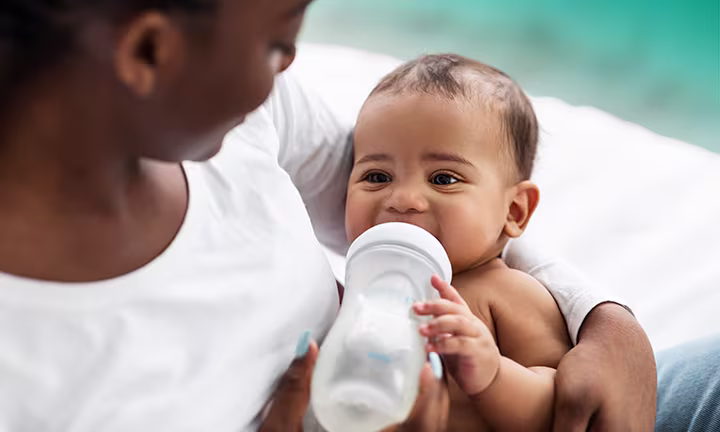when do babies hold their own bottle