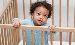 Baby boy standing in crib