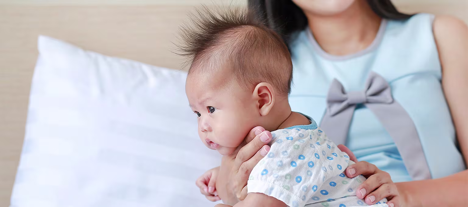 Mom holding baby to help prevent hiccups