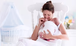 A caregiver holding a newborn baby in their arms