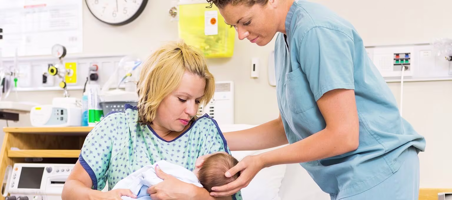 Mother and nurse holding newborn baby