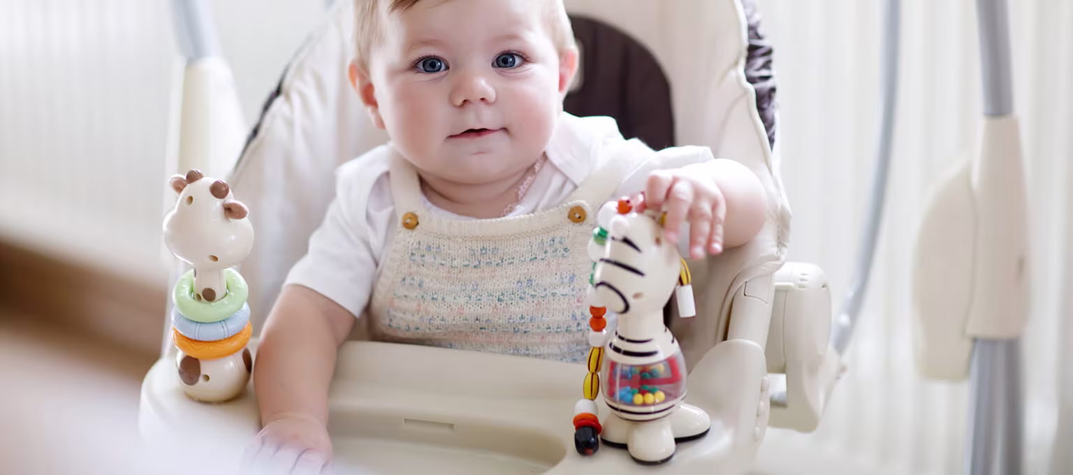 A baby enjoying a ride in a baby swing.