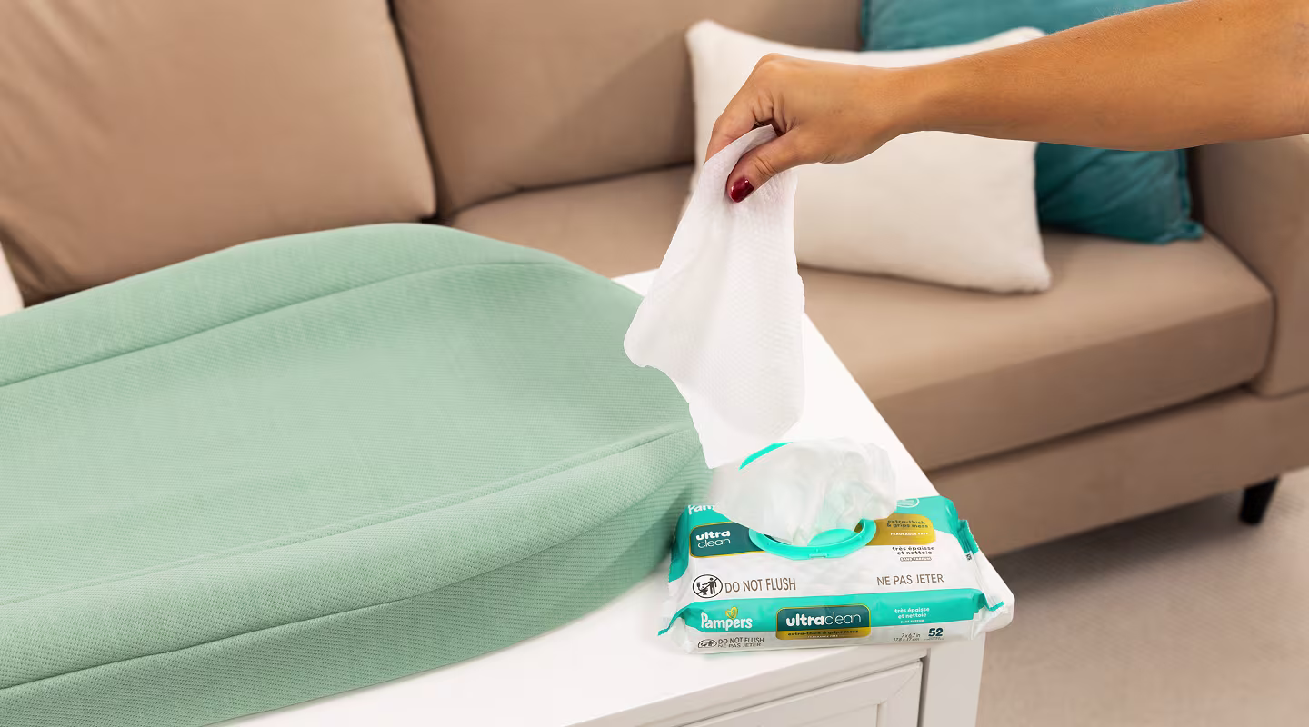 Maman sort une lingette Ultraclean du distributeur posé sur une table à langer.