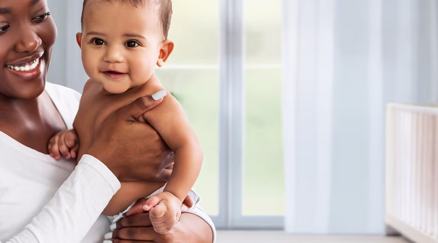 A caring parent holds her baby, feeling their soft protected skin