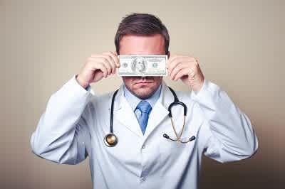 This is a photo of a doctor who has a $100 bill covered on his face. 