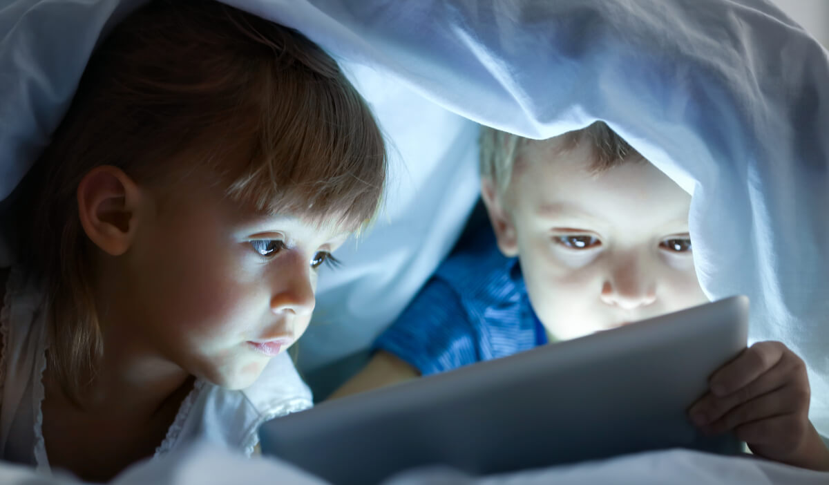 brother and sister watching tablet 