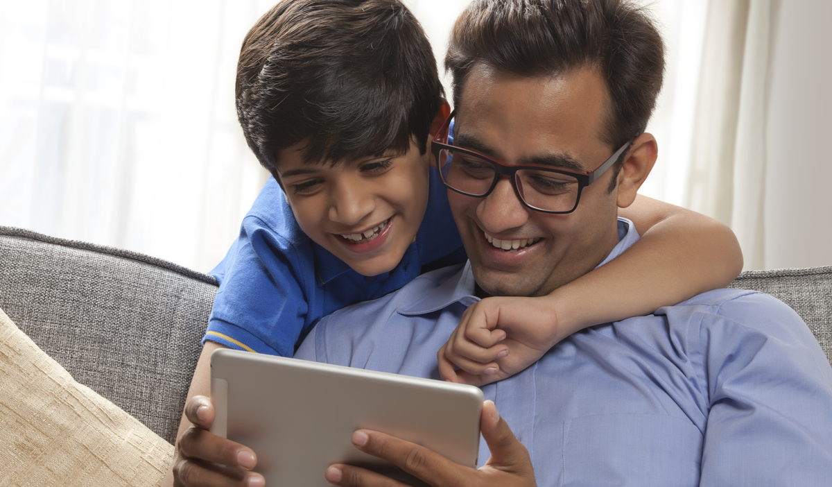 happy father and son holding tablet