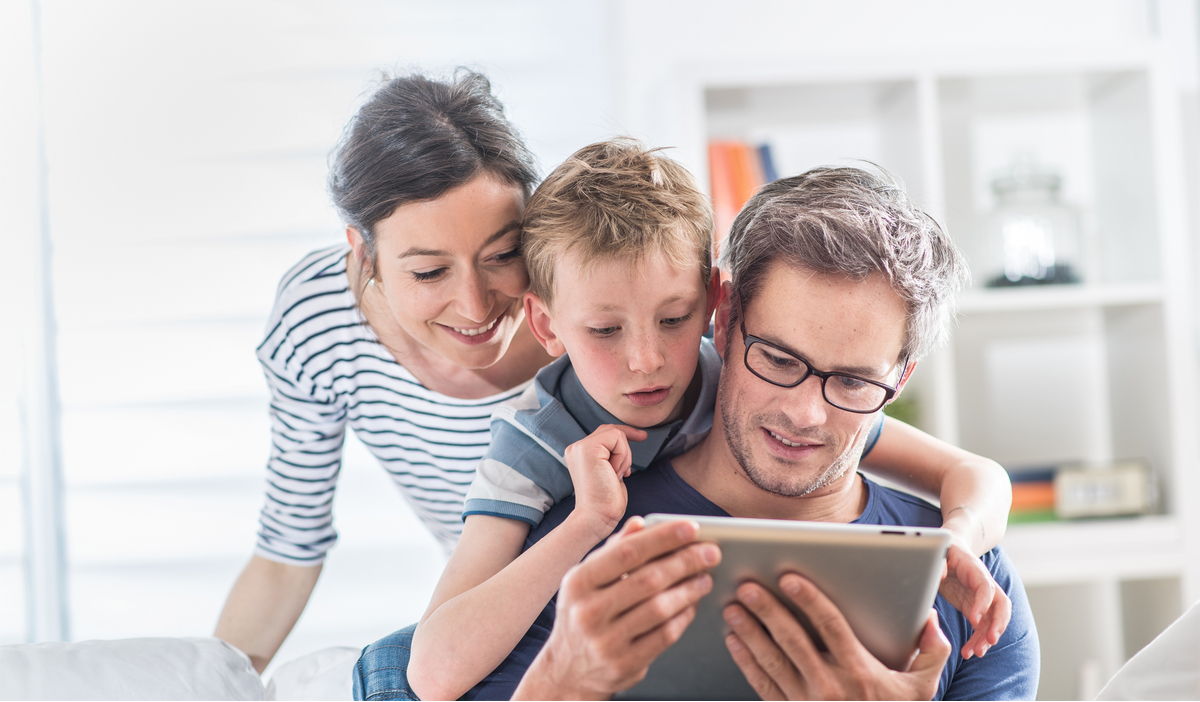 Mom, dad, and son playing game on a tablet